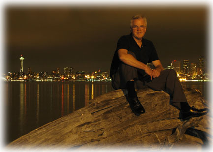 Steve in front of Seattle skyline at night.